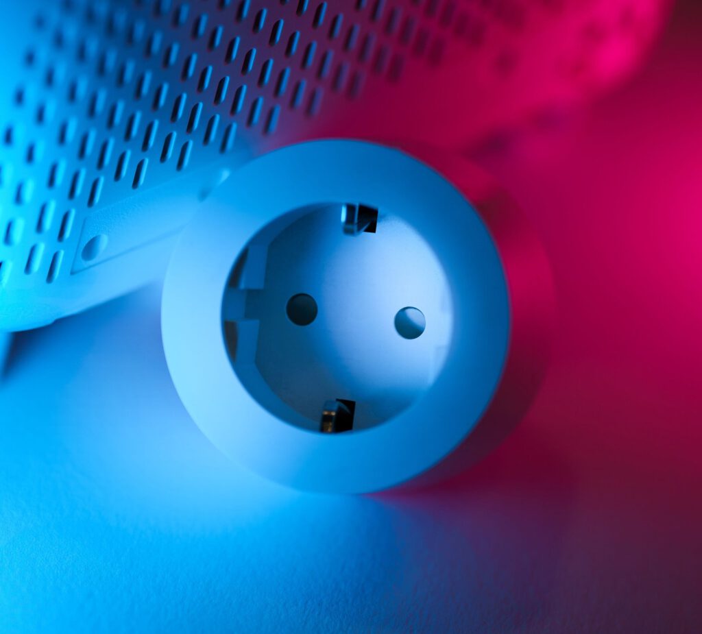 Slimme stekker in blauw-roze licht als illustratie van meten en schakelen